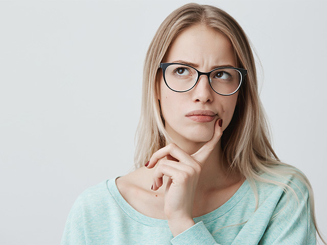 Młoda kobieta w okularach zastanawiająca się, czym jest marsz alergiczny